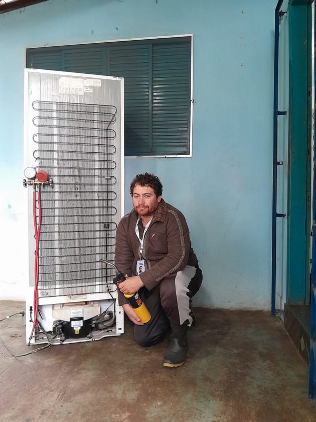 Técnico consertando geladeira
